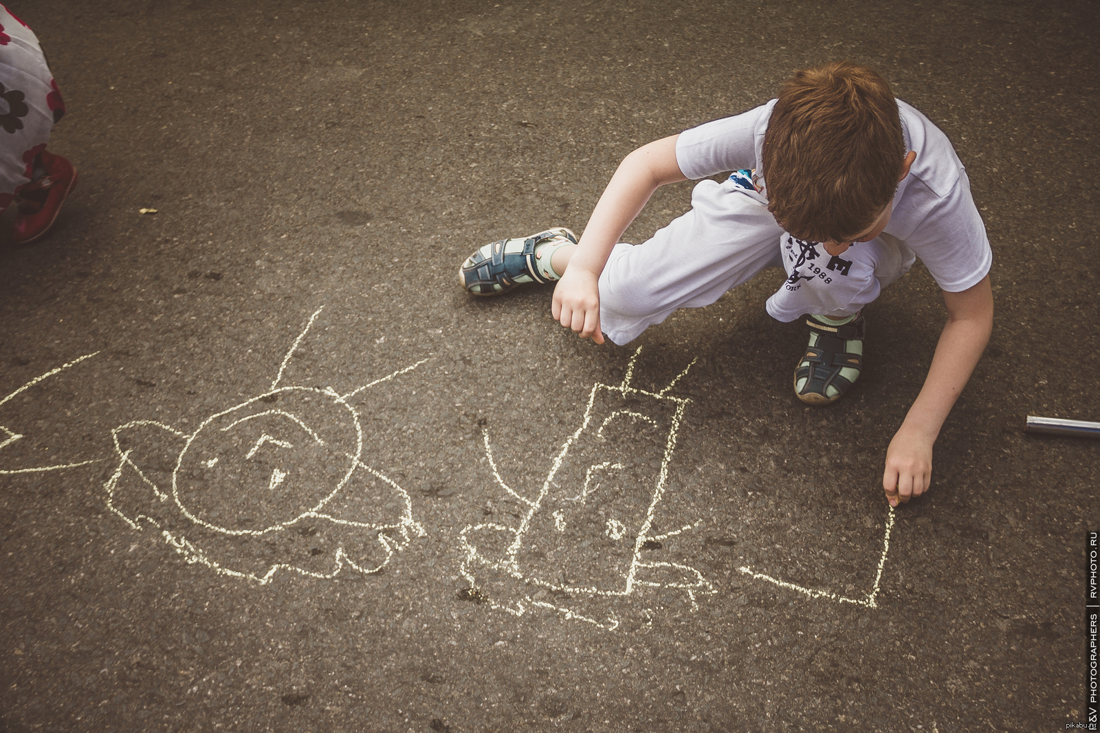 Дети рисуют на асфальте мелом