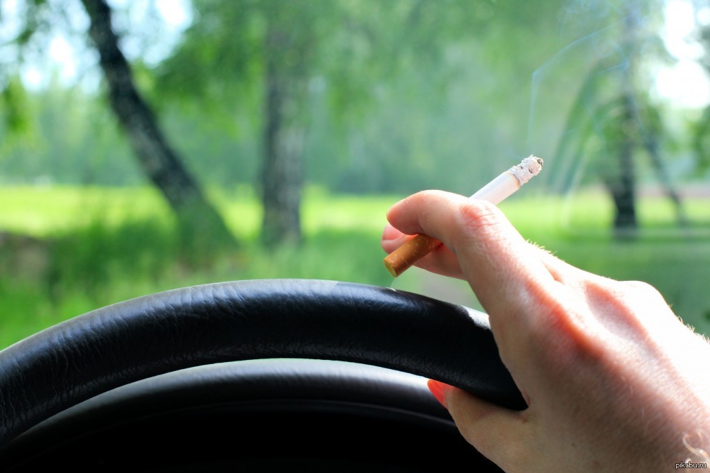 Можно курить в машине. Курение в авто. Рука сигарета руль. За рулем. Курит в машине.
